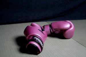 Image of pink boxing gloves on a grey mat