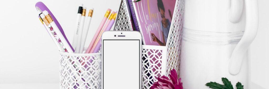 Photography of a pen pot, phone, magazine rack and a white jug used to provide health and wellness admin support to holistic business owners